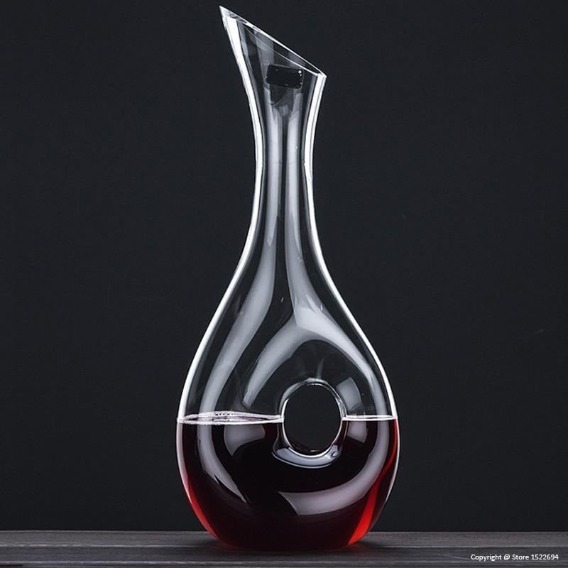 Clear glass wine decanter with red wine on a black background