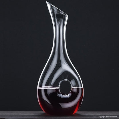 Clear glass wine decanter with red wine on a black background