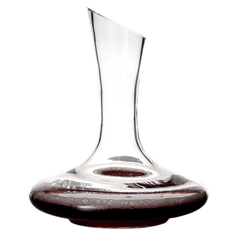 Clear wine decanter with red wine at the base on a white background