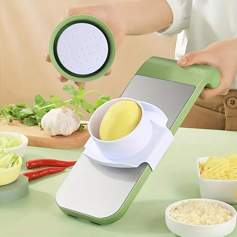 Person using a green and white kitchen tool to slice vegetables on a table with ingredients around.