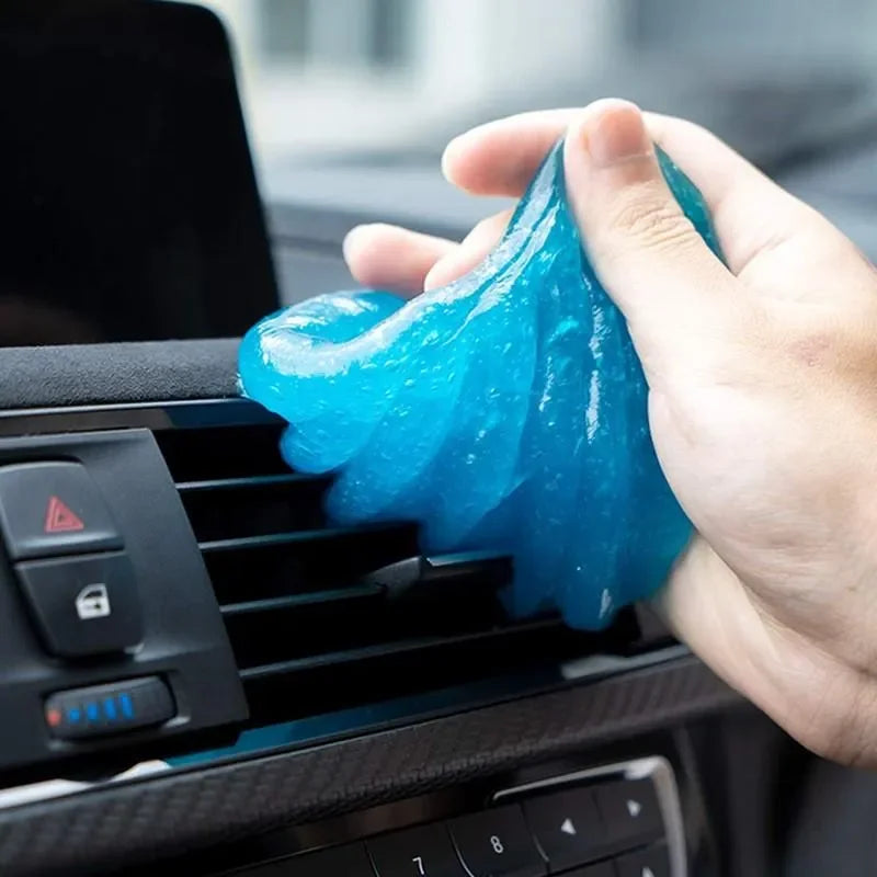 Hand using blue gel to clean car air vent