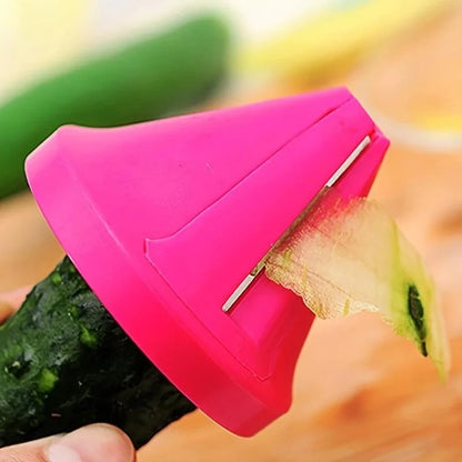 Pink vegetable peeler cutting a cucumber with a blurred background of fruits