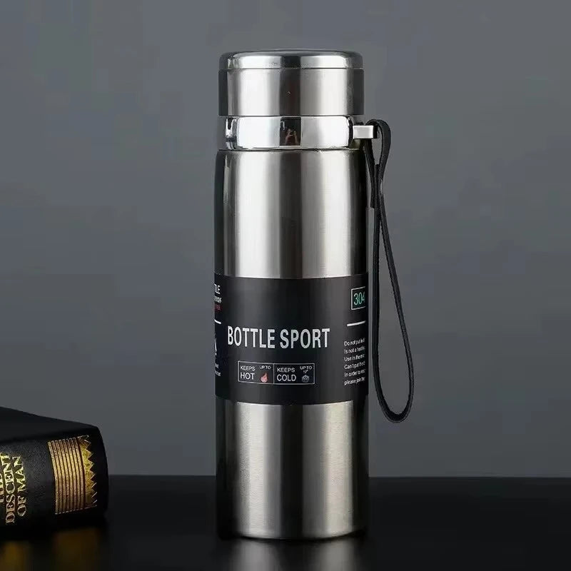 Silver insulated bottle with a black label on a dark surface