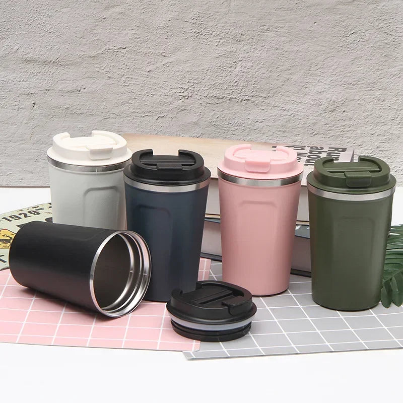 Set of five insulated travel mugs in different colors on a checkered surface.