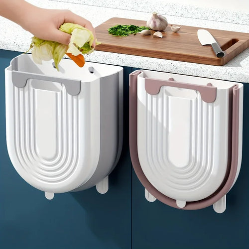 Two wall-mounted vegetable dryers on a kitchen counter with a hand using one of them.
