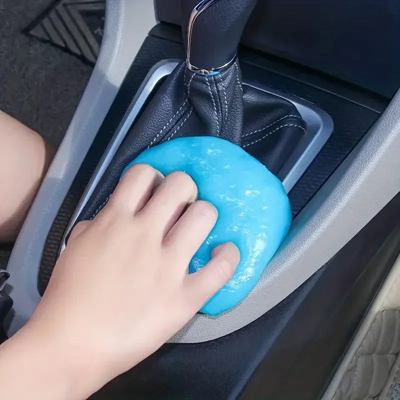 Hand pressing a blue gear shift cover in a car.
