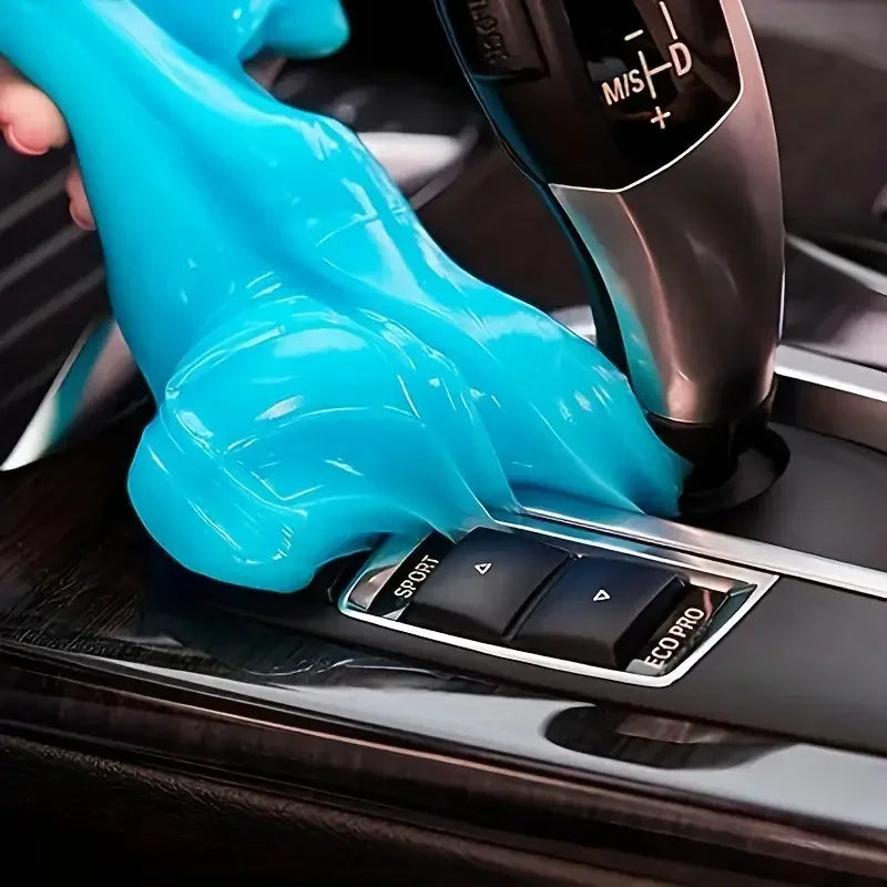 Hand wearing a blue glove operating a car gear shift lever.