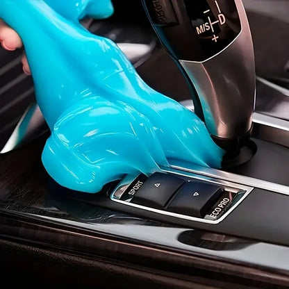 Hand wearing a blue glove operating a car gear shift lever.