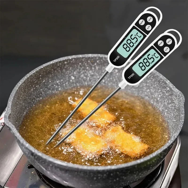Two digital thermometers inserted into frying food in oil, showing temperature.
