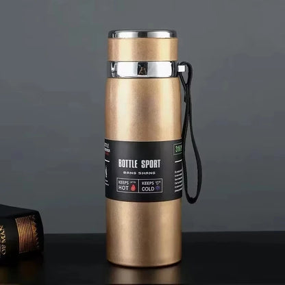 Gold insulated bottle with black label on a dark background
