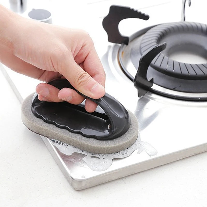 Person using a black and gray cleaning pad on a stovetop